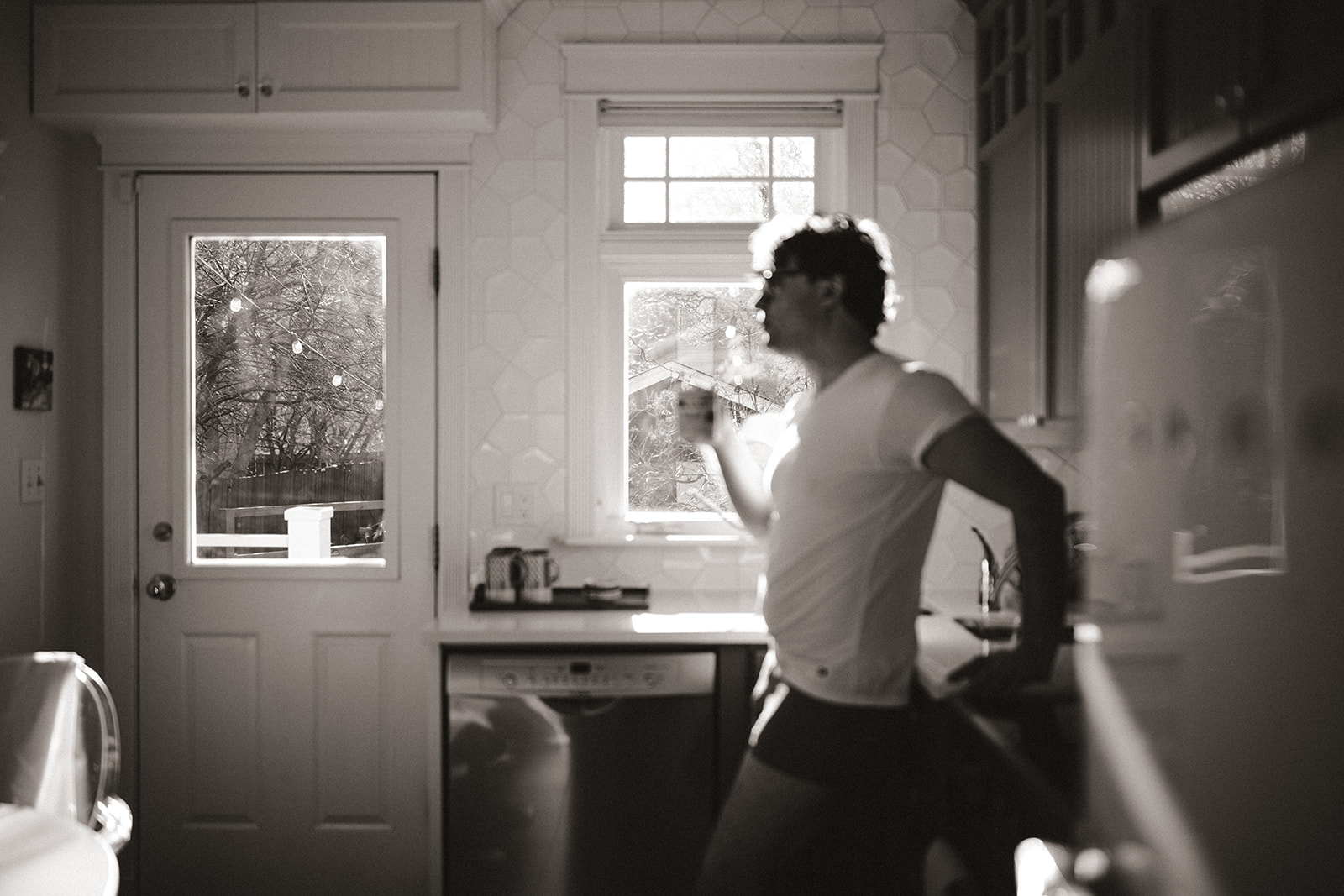 young man drinking coffee in his Alberta kitchen